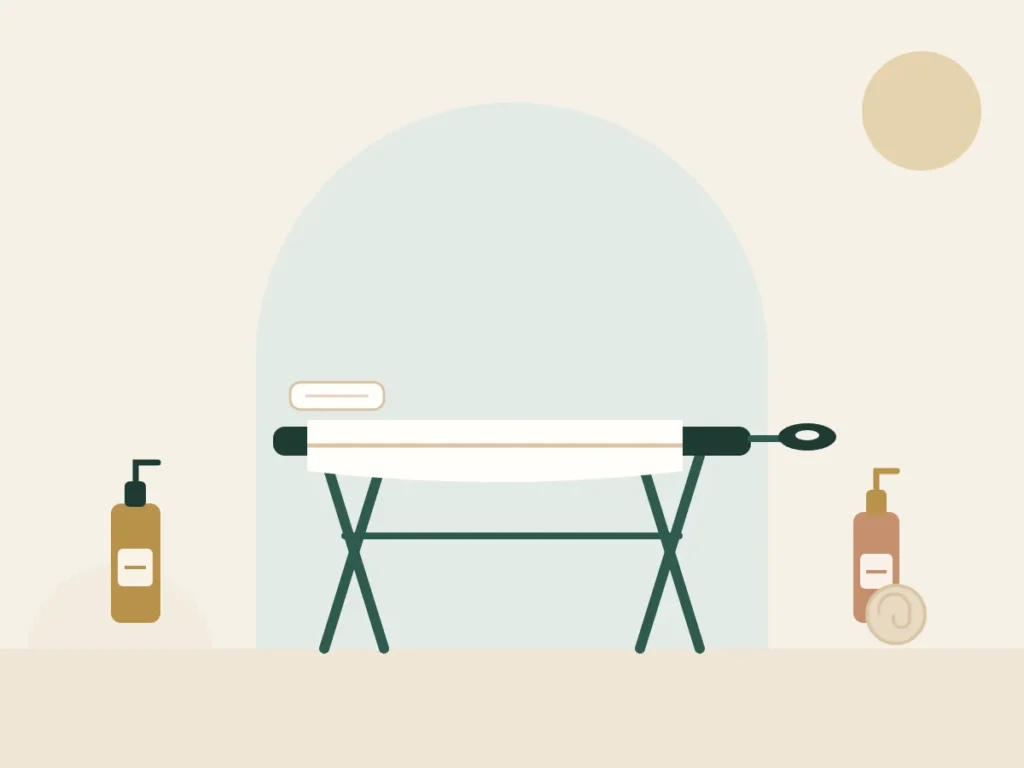 Massage table with a full-length towel and two oil bottles for a full body massage at home